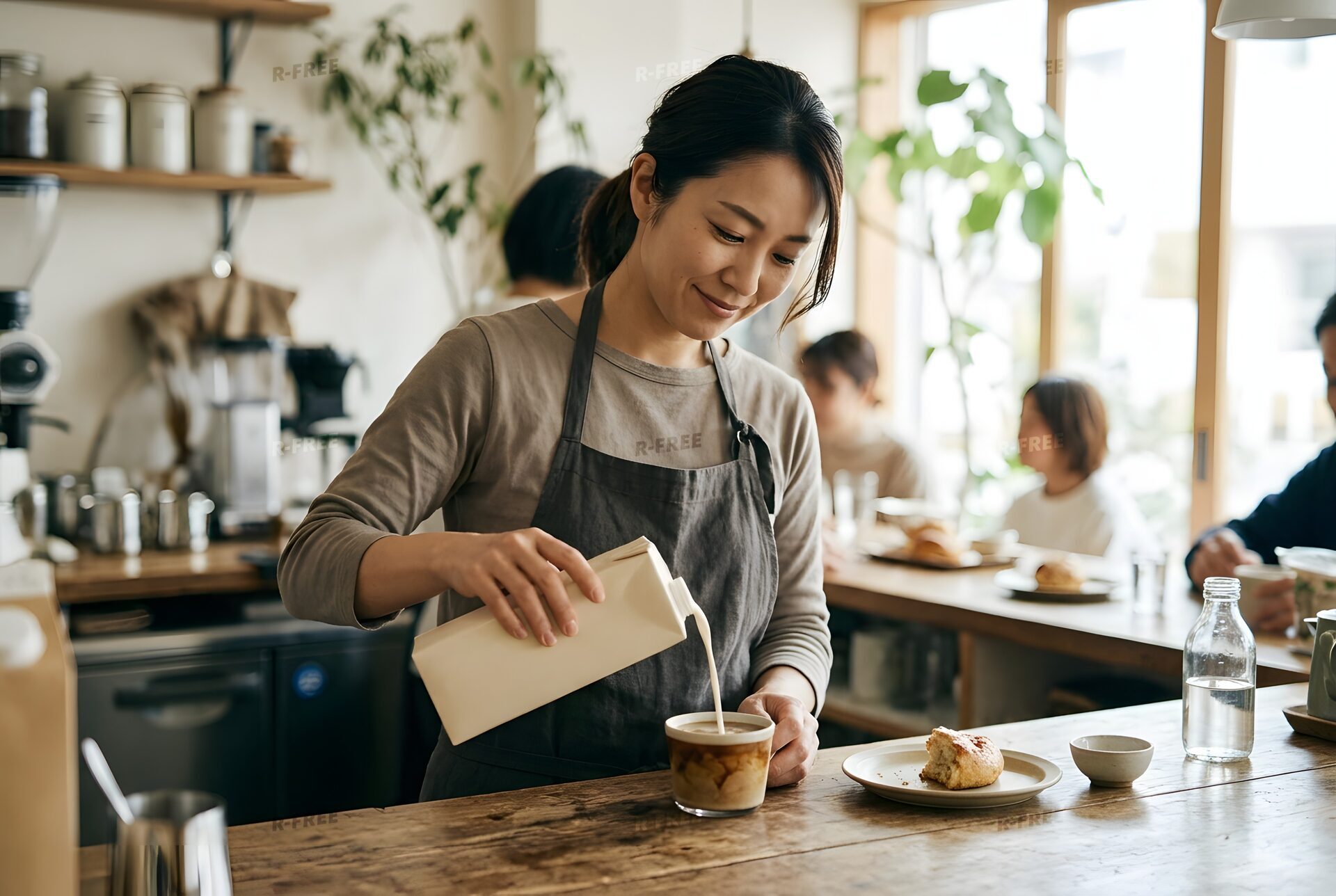 コーヒーにオーツミルクを注ぐ女性