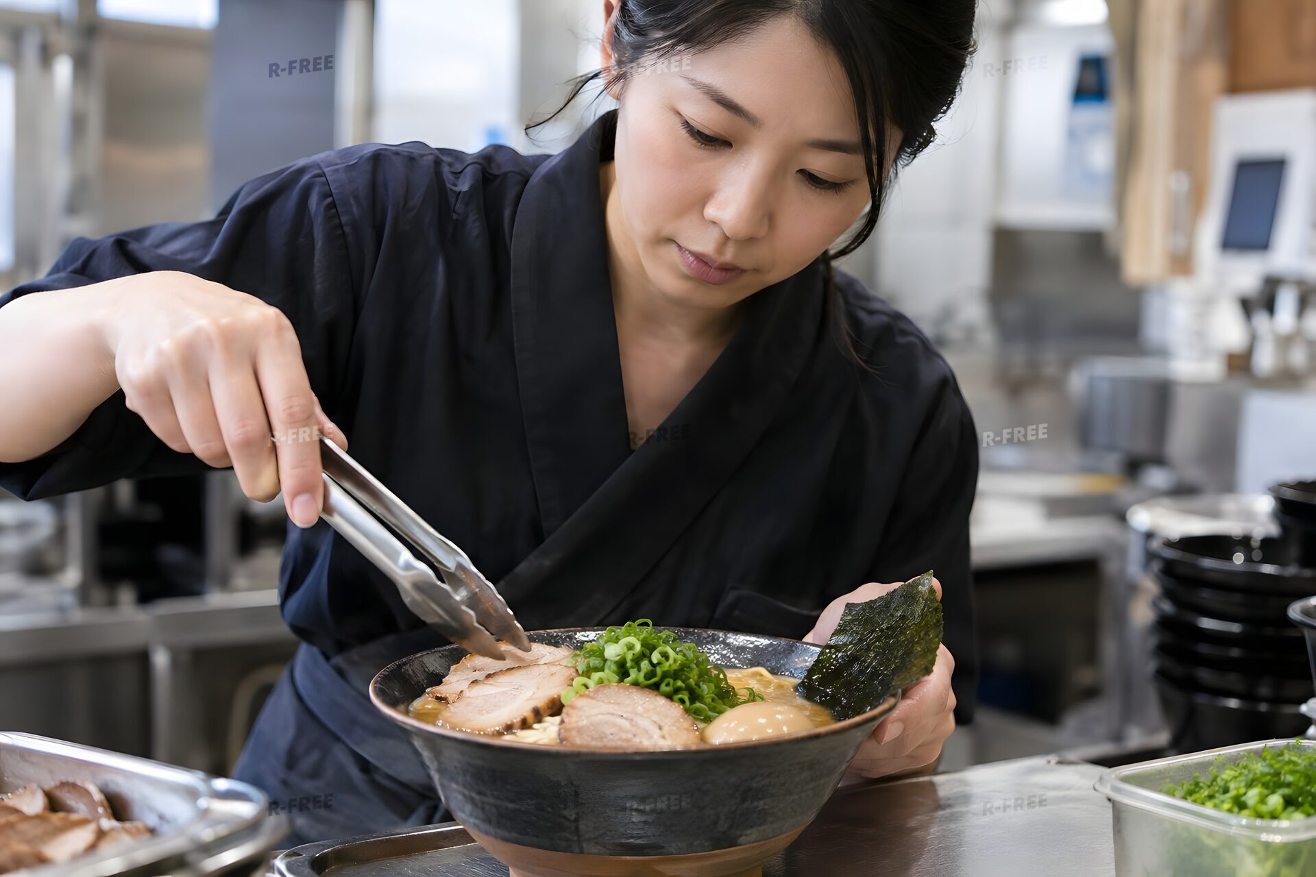 チャーシューをのせるラーメン店の店員