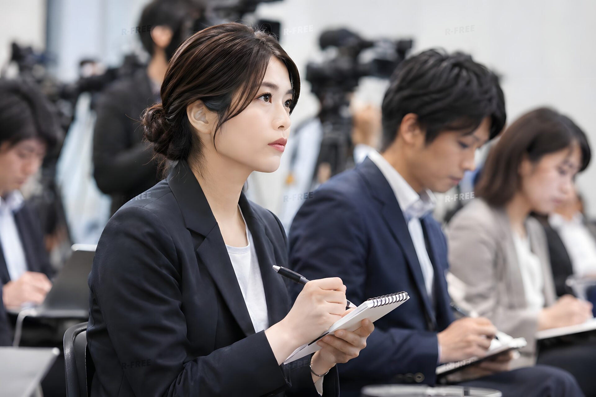 記者会見でメモを取る記者