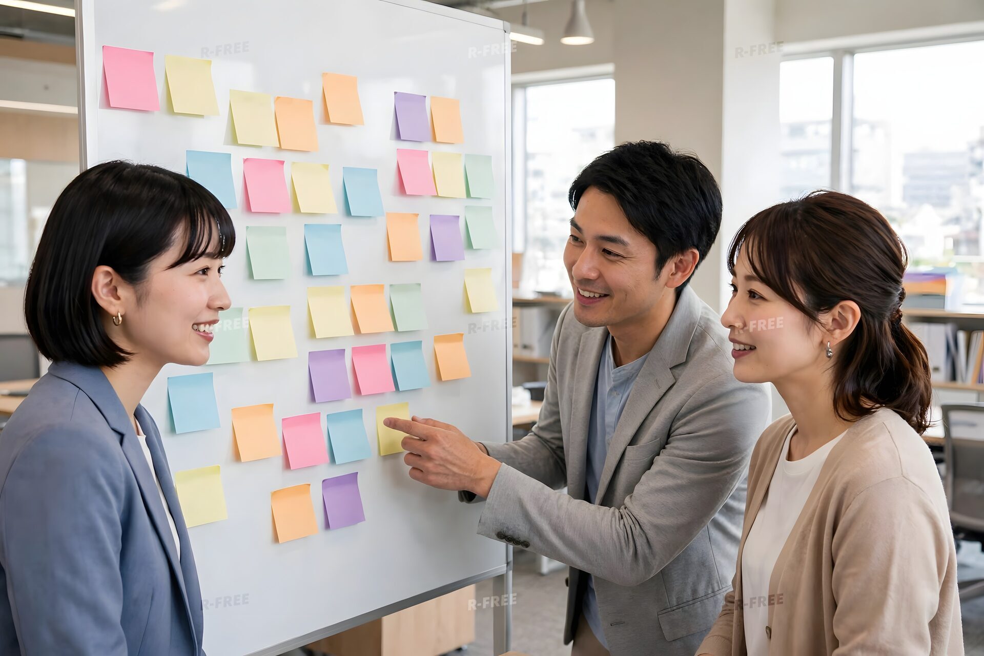 ホワイトボードの付箋を前にアイデアを出し合うチーム