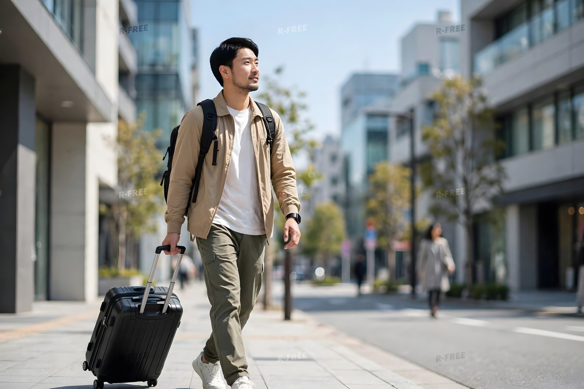 スーツケースを引いて街を歩く男性