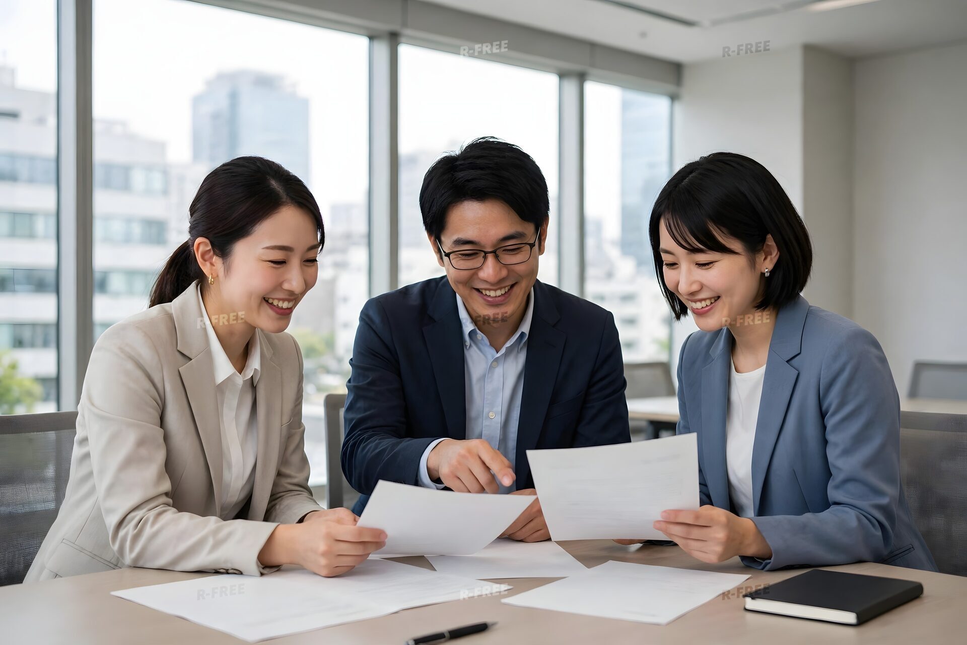 書類を見ながら笑顔で相談する3人の会社員