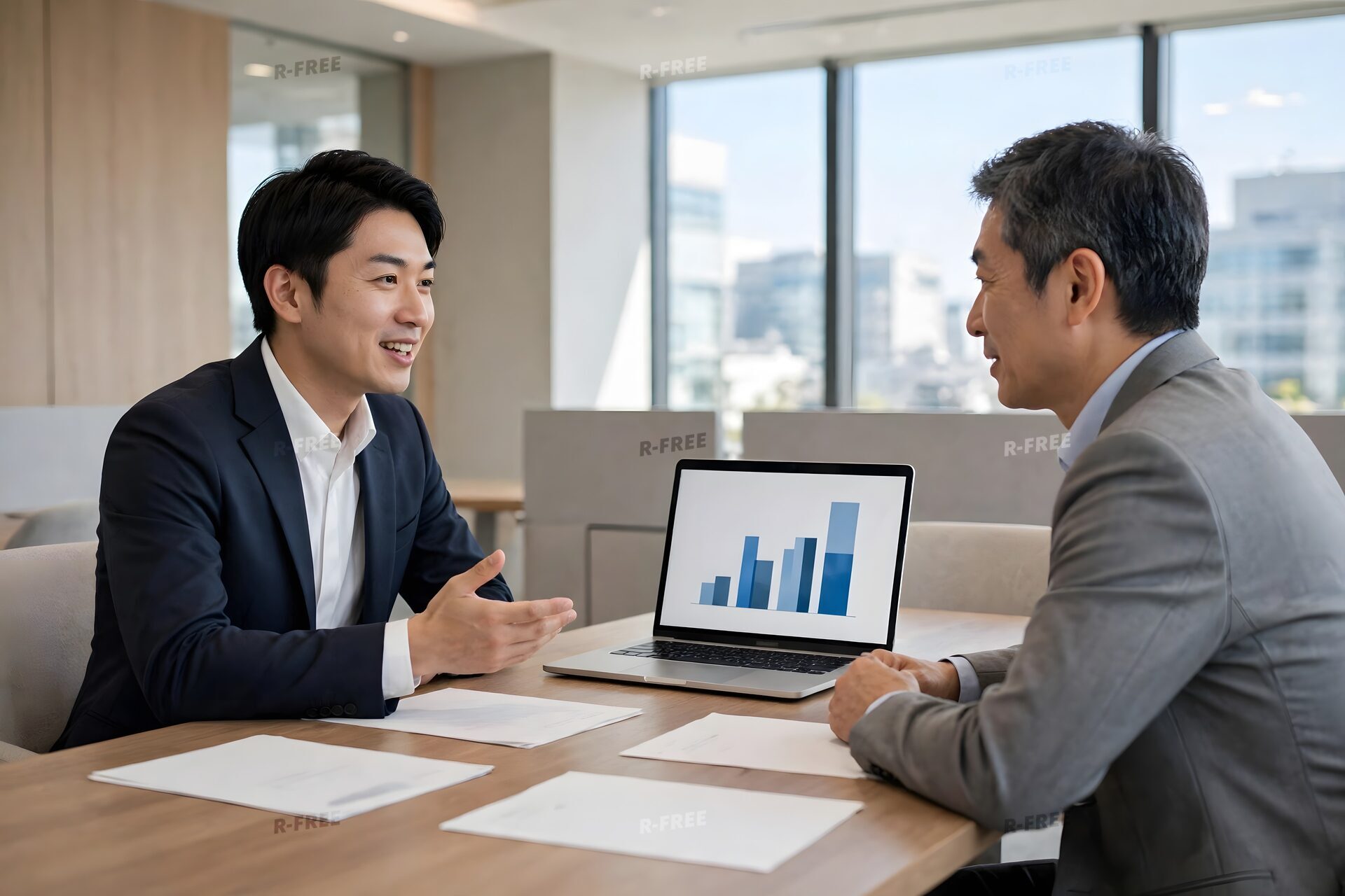 ノートパソコンのグラフを見せて説明する営業担当