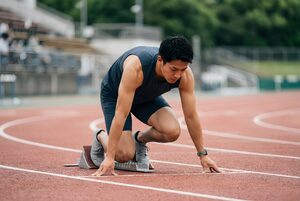 スタートブロックで構える短距離の選手