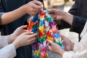 千羽鶴を持ち寄る人々の手元