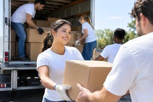 トラックから支援物資の箱を降ろすボランティア