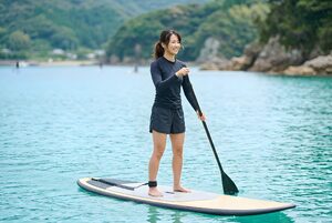 パドルボードで海を進む女性