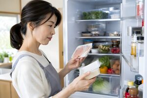冷蔵庫の食品を確認する40代女性