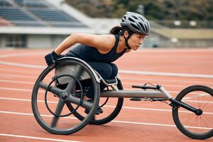 レース用の車いすで走る女性