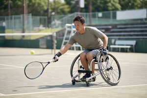 車いすテニスをする男性