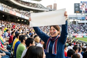 横断幕を掲げて応援する女性