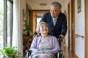 車いすの妻を介護する高齢の夫