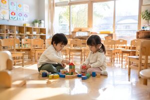 空席の目立つ保育室で遊ぶ2人の幼児