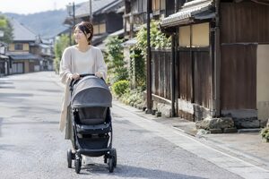 人通りの少ない町でベビーカーを押す母親