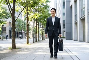 スニーカーで歩くスーツ姿の男性