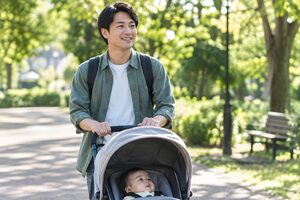 平日の公園でベビーカーを押す父親