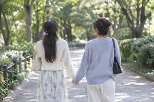 手をつないで公園を歩く女性カップル