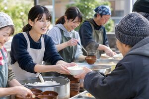 屋外で炊き出しをするボランティア