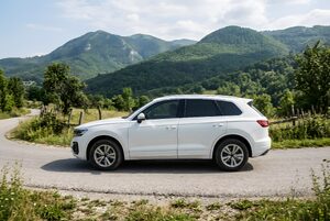 山あいの道を走る白いSUV
