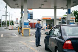 ガソリンスタンドで車を誘導する店員