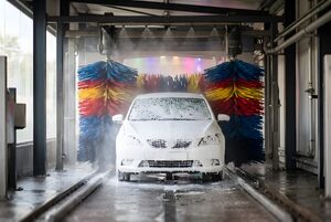 洗車機で泡に包まれる白い車