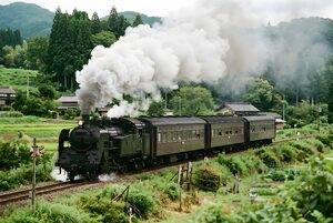 蒸気を上げて走る蒸気機関車