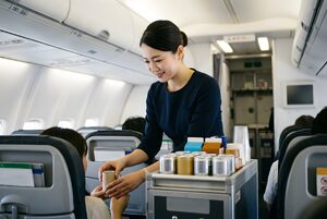 機内でドリンクを配る客室乗務員