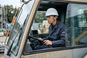 クレーン車の運転席で操作するオペレーター