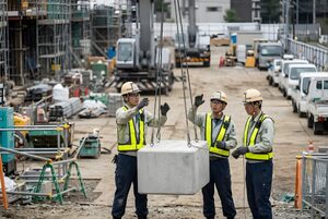 合図をしてクレーンの作業を誘導する作業員