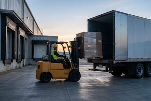 倉庫の荷役口でトラックに積み込むフォークリフト
