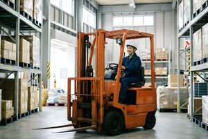 倉庫でフォークリフトを運転する女性