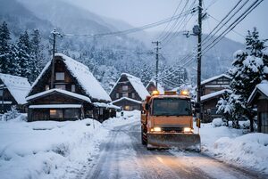 夜明けの村道を除雪するトラック