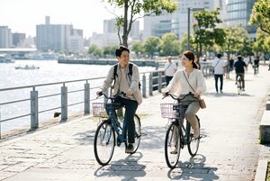 街をシェアサイクルで巡る観光客の二人