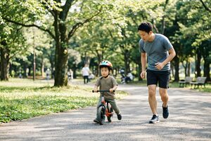 ストライダーで走る男の子と父親