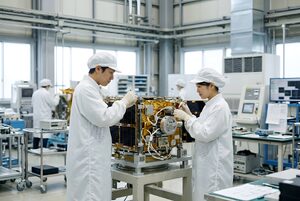 クリーンルームで衛星を組み立てる技術者たち
